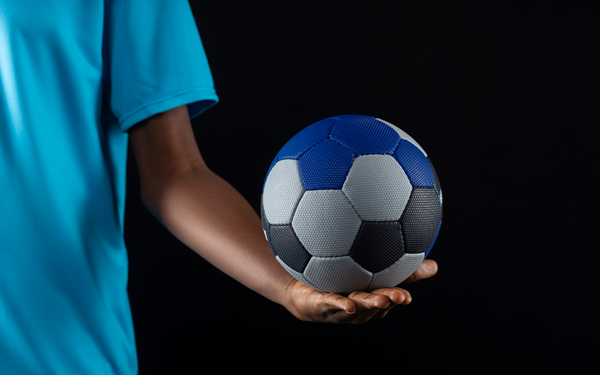 A young athlete holding a football, representing the discipline and technical precision of the Silver Studs FC academy curriculum.